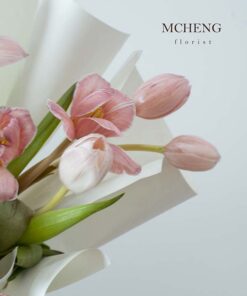 Góc nghiêng tôn lên lớp giấy gói trắng tinh khôi của bó hoa Tulip hồng