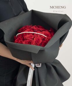 Kích thước thực tế bó hoa hồng đỏ gói giấy đen cá tính trên tay khách hàng