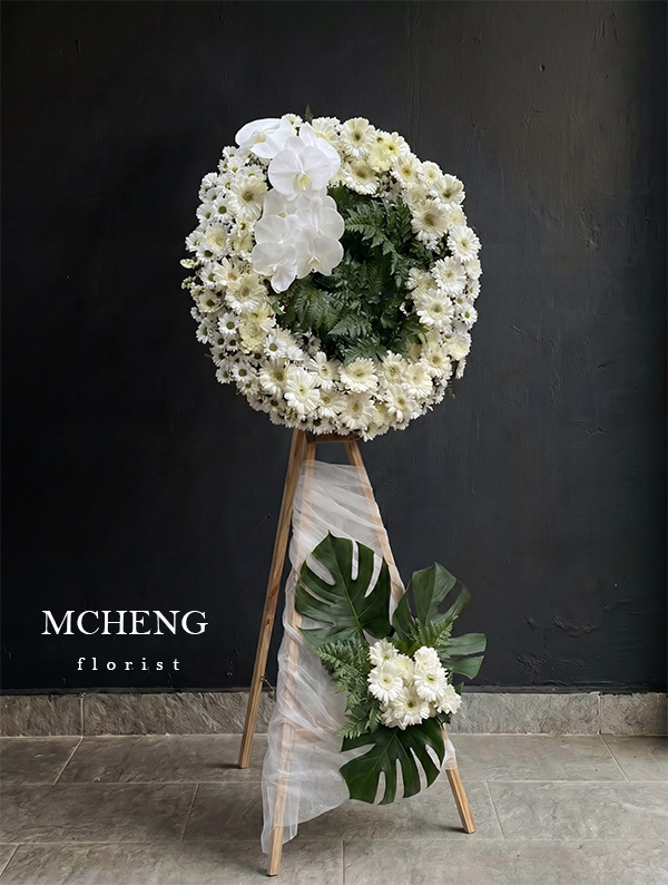 Goc Nghieng Ke Hoa Chia Buon Vong Tron Trang Mcheng Góc nghiêng tôn lên dải voan trắng và lá Monstera bệ vệ của kệ hoa chia buồn