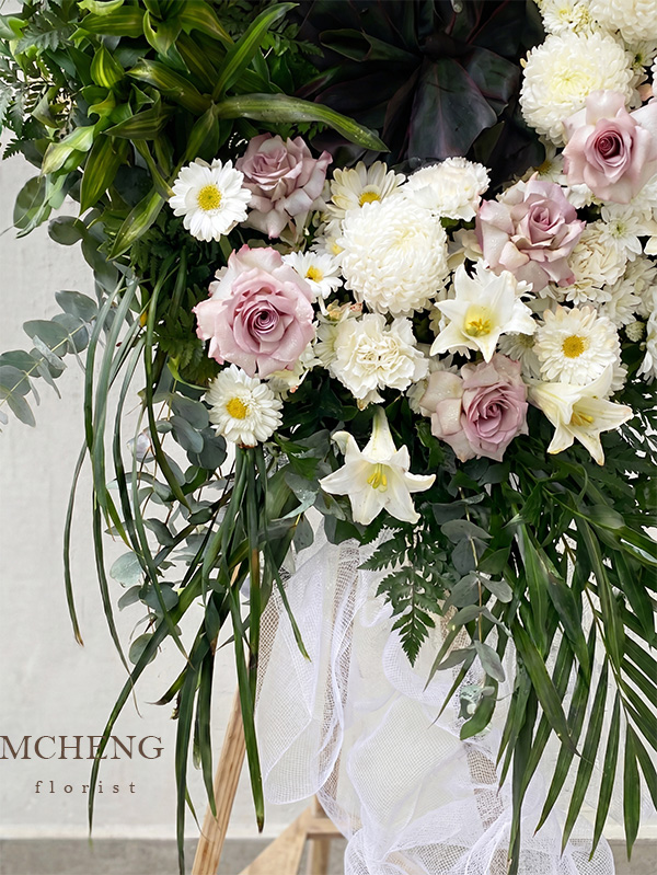 Chi Tiet Ke Hoa Chia Buon Trang Tim Khoi Mcheng Florist Cận cảnh nghệ thuật bất đối xứng của hoa hồng tím khói và lá xanh trên kệ hoa chia buồn