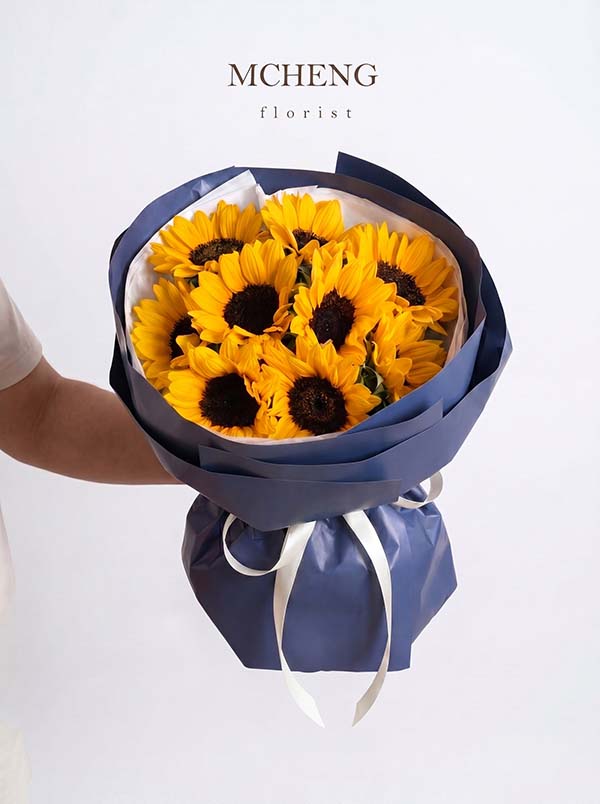 Hoa Bó Tốt Nghiệp Hướng Dương Navy Kiêu Hãnh - Mcheng Florist Mẫu hoa bó tốt nghiệp hướng dương phối giấy xanh navy sang trọng tại Mcheng Florist