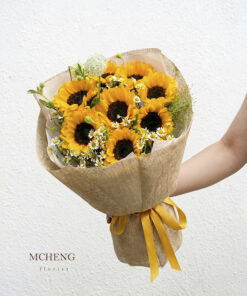 Góc nghiêng tôn lên lớp giấy lưới thô mộc mạc và nơ vàng của bó hoa tốt nghiệp