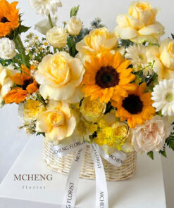 Cận cảnh sắc vàng rực rỡ của hoa hướng dương và hoa hồng tone vàng cam trong giỏ mây